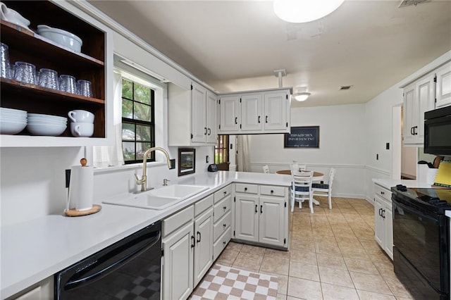 4950 Santos Dr E, Mobile, AL 36619 - kitchen featuring black appliances, a sink, light countertops, a peninsula, and open shelves