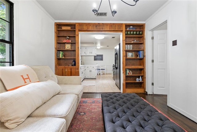 4950 Santos Dr E, Mobile, AL 36619 - living room with wood finished floors, crown molding, a chandelier, and baseboards