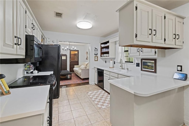 4950 Santos Dr E, Mobile, AL 36619 - kitchen with black appliances, a sink, a peninsula, light countertops, and a chandelier