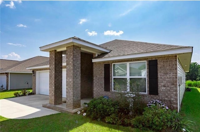 view of front of home with a garage, concrete driveway, a front lawn, and roof with shingles