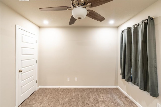 spare room with carpet floors, ceiling fan, and baseboards