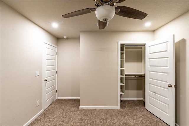 unfurnished bedroom featuring baseboards, ceiling fan, a spacious closet, carpet flooring, and a closet