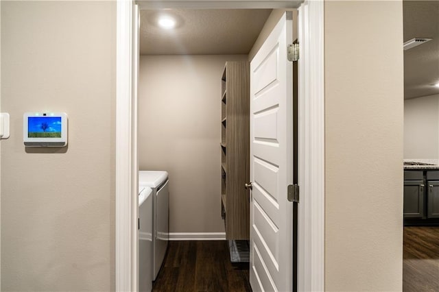 laundry room featuring laundry area, separate washer and dryer, dark wood-type flooring, and baseboards