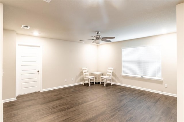 unfurnished dining area featuring dark wood-style floors, visible vents, ceiling fan, and baseboards