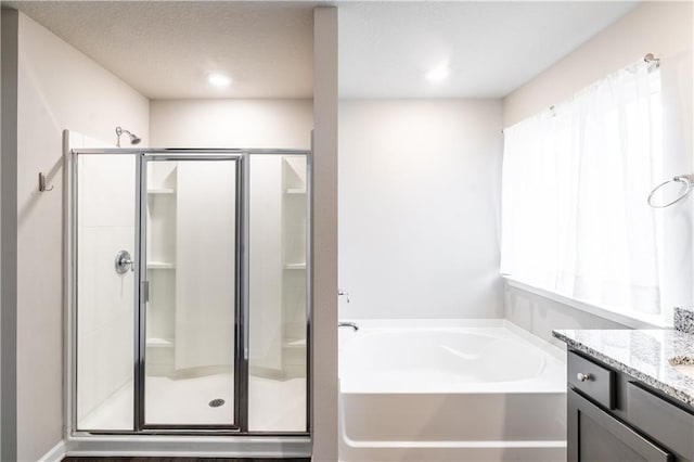 bathroom featuring a stall shower, vanity, and a bath