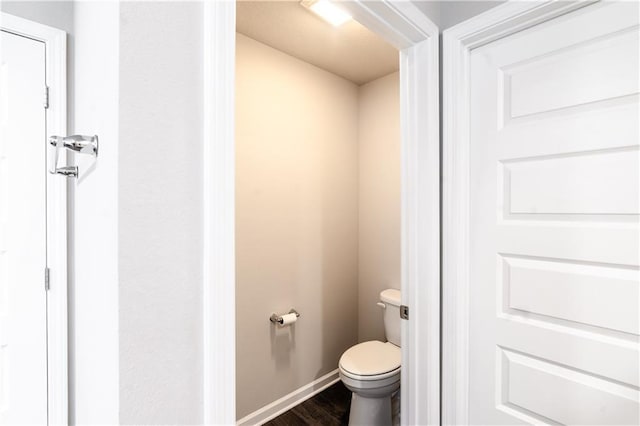 bathroom featuring wood finished floors, toilet, and baseboards