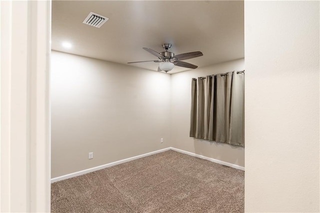 carpeted spare room featuring baseboards, visible vents, and a ceiling fan