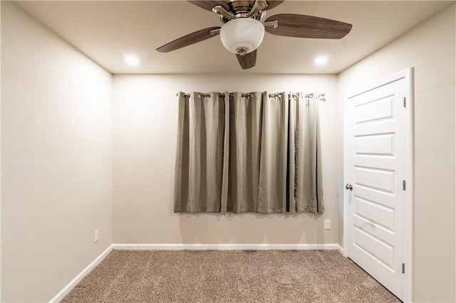 carpeted empty room featuring ceiling fan and baseboards