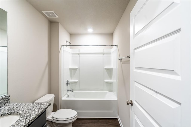 full bath featuring visible vents, toilet, wood finished floors, bathtub / shower combination, and vanity