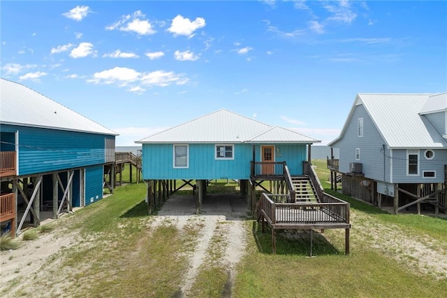 2528 Bridgeview Dr, Dauphin Island, AL 36528 - back of property featuring a carport, dirt driveway, stairway, and a yard