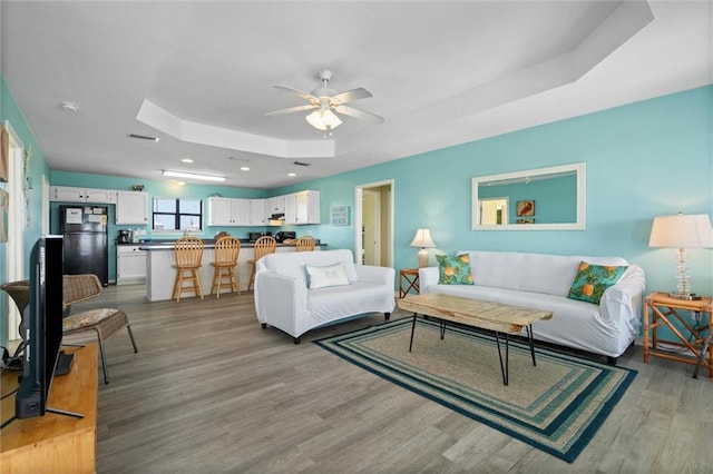 2528 Bridgeview Dr, Dauphin Island, AL 36528 - living area with a tray ceiling, ceiling fan, light wood-type flooring, a skylight, and recessed lighting