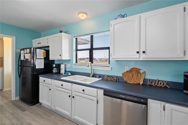 2528 Bridgeview Dr, Dauphin Island, AL 36528 - kitchen with dishwasher, freestanding refrigerator, white cabinetry, dark countertops, and light wood finished floors