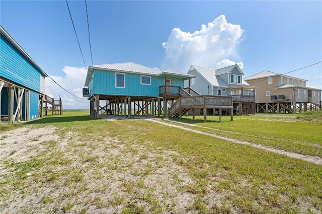 2528 Bridgeview Dr, Dauphin Island, AL 36528 - rear view of property with stairway, a yard, and a metal roof