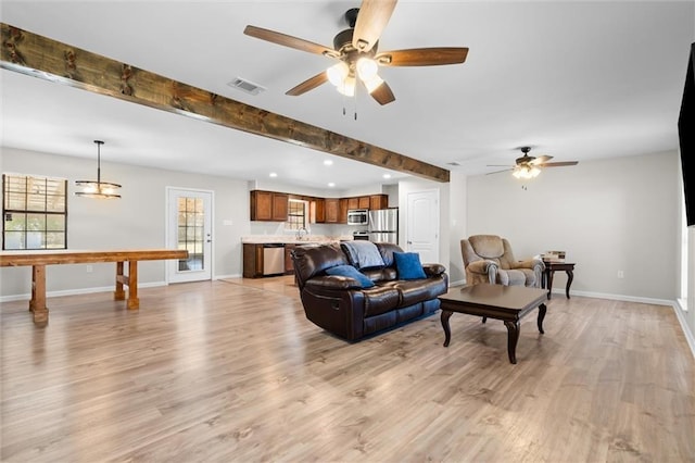 living room featuring light wood finished floors, visible vents, baseboards, beamed ceiling, and recessed lighting