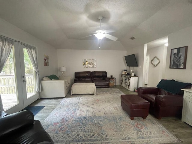 living room with a textured ceiling, french doors, light hardwood / wood-style floors, vaulted ceiling, and ceiling fan