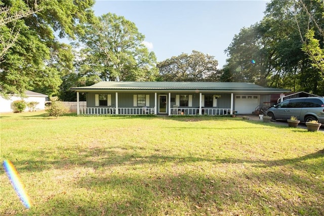 view of front of house with a porch, a front lawn, an attached garage, and metal roof
