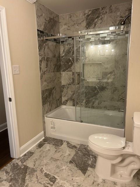 13580 Laco Cooper Rd, Wilmer, AL 36587 - bathroom featuring toilet, shower / bath combination with glass door, and baseboards