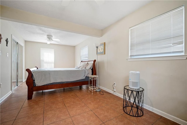 bedroom featuring tile patterned floors, baseboards, and a textured ceiling
