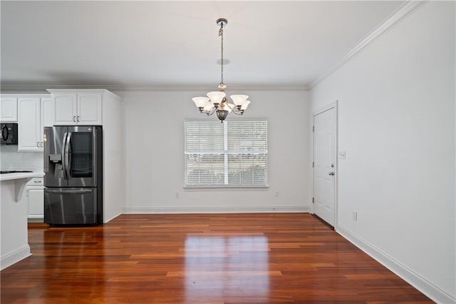 404 Savannah Ln, Foley, AL 36535 - unfurnished dining area featuring dark wood-type flooring, crown molding, a notable chandelier, and baseboards
