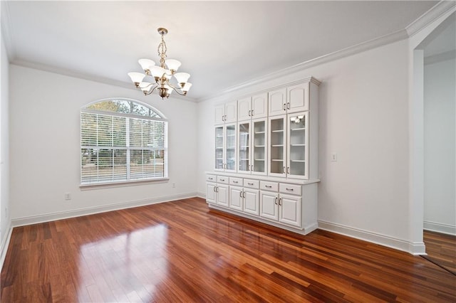 404 Savannah Ln, Foley, AL 36535 - empty room featuring baseboards, dark wood-type flooring, an inviting chandelier, and crown molding