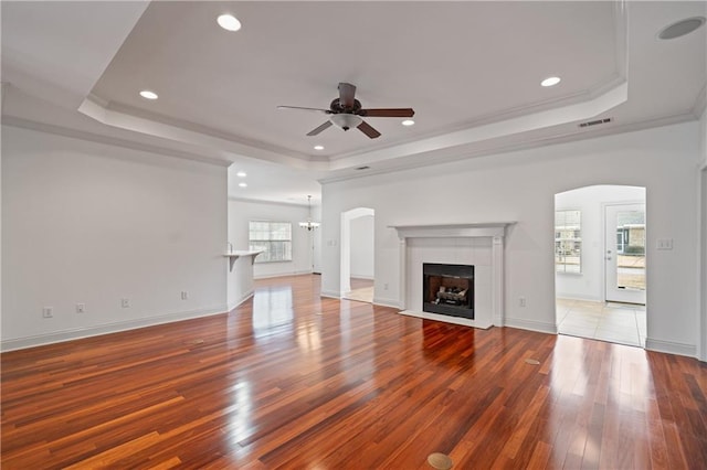 404 Savannah Ln, Foley, AL 36535 - unfurnished living room featuring a tray ceiling, a tile fireplace, wood finished floors, and crown molding