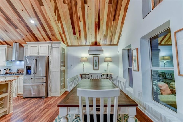 dining area with light wood-type flooring and wooden ceiling