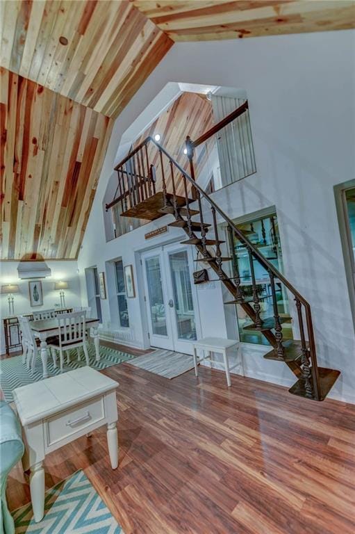 living room featuring hardwood / wood-style floors, high vaulted ceiling, and french doors