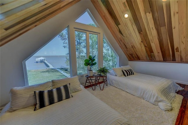 bedroom with vaulted ceiling and a water view