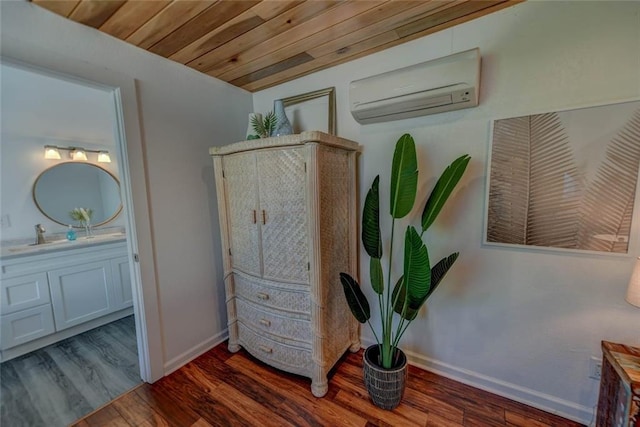 interior space with wood ceiling, a wall mounted air conditioner, sink, and wood-type flooring