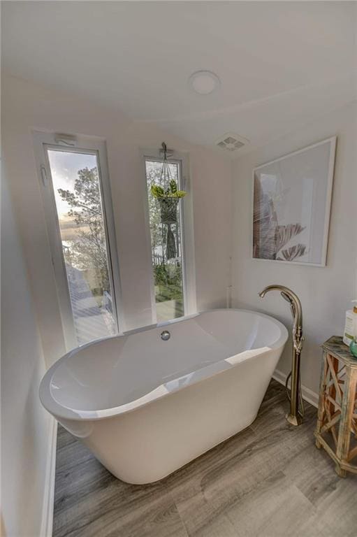 bathroom featuring a tub to relax in and hardwood / wood-style floors