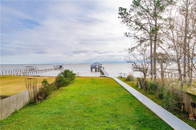 dock area with a water view and a lawn