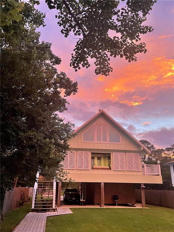 back house at dusk featuring a lawn