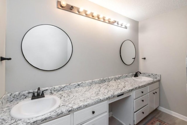 11525 Lott Rd, Chunchula, AL 36521 - full bathroom with double vanity, a textured ceiling, and wood finished floors