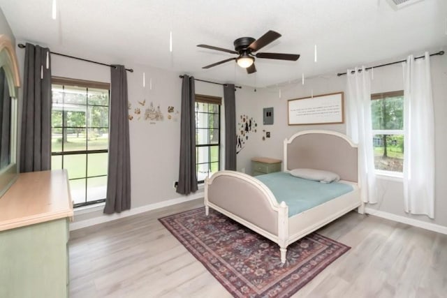 11525 Lott Rd, Chunchula, AL 36521 - bedroom with light wood-type flooring, multiple windows, a textured ceiling, and a ceiling fan