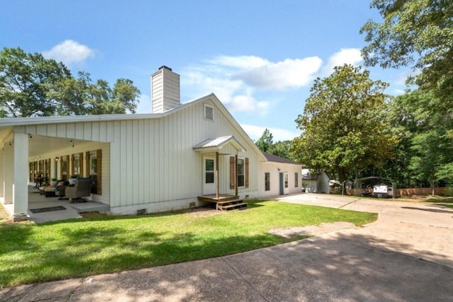 11525 Lott Rd, Chunchula, AL 36521 - rear view of house with a yard, a chimney, driveway, crawl space, and a patio area