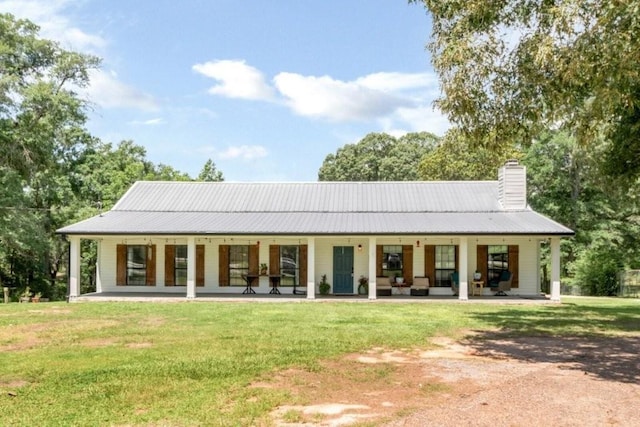 11525 Lott Rd, Chunchula, AL 36521 - back of house featuring covered porch, a lawn, a chimney, and a metal roof