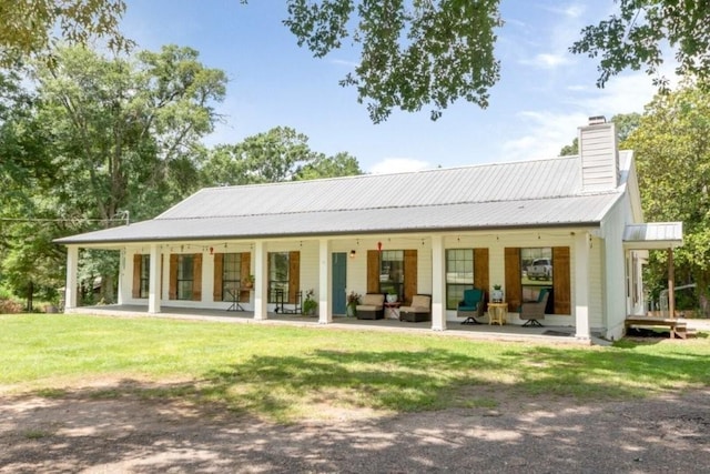 11525 Lott Rd, Chunchula, AL 36521 - back of property featuring a chimney, a lawn, a metal roof, a patio area, and outdoor lounge area