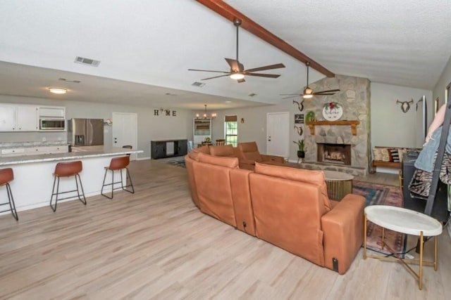 11525 Lott Rd, Chunchula, AL 36521 - living room featuring ceiling fan, a stone fireplace, light wood-style flooring, and a chandelier