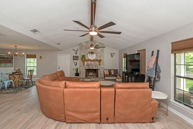 11525 Lott Rd, Chunchula, AL 36521 - living room with wood finished floors, a ceiling fan, lofted ceiling, a fireplace, and a textured ceiling