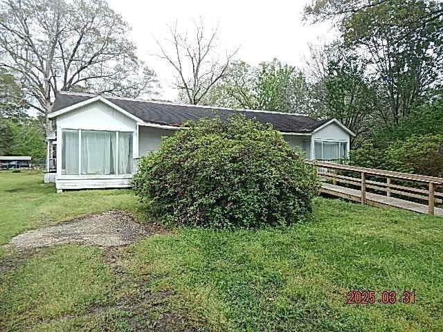view of side of home with fence and a lawn