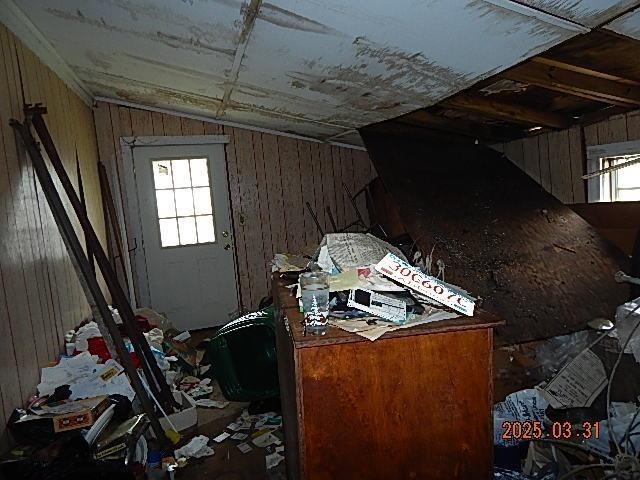 misc room featuring lofted ceiling and wooden walls