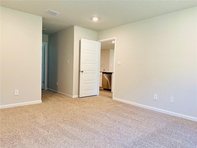 spare room featuring light carpet