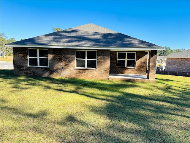 back of property with a yard and a patio area