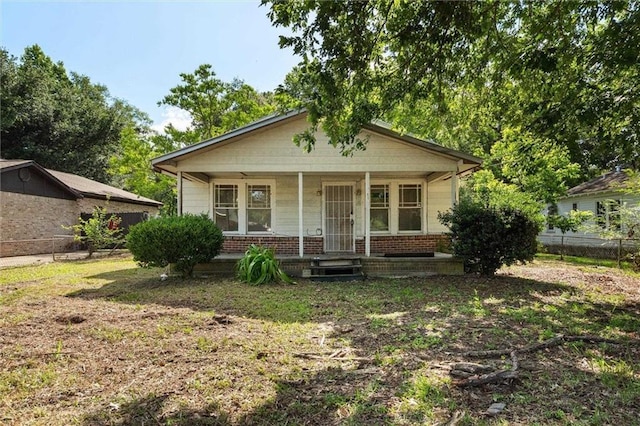 672 Burden St, Mobile, AL 36607 - bungalow-style home featuring a porch, brick siding, and fence