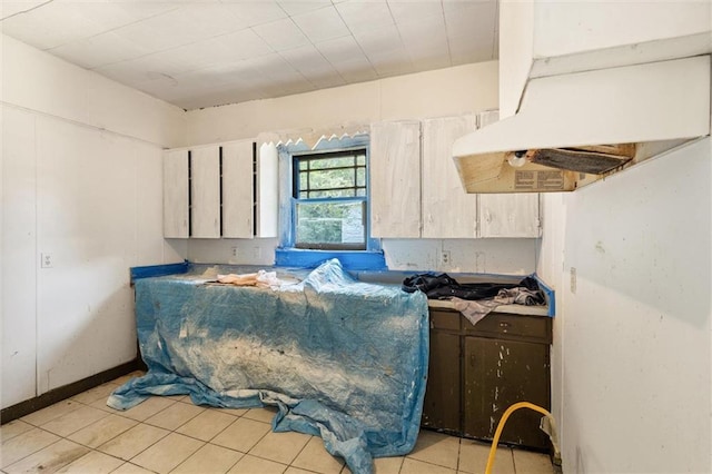 672 Burden St, Mobile, AL 36607 - kitchen featuring under cabinet range hood and light tile patterned flooring