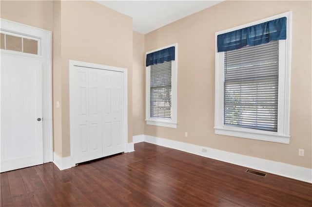 unfurnished bedroom featuring a closet and dark hardwood / wood-style floors