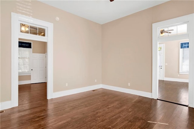 unfurnished room featuring dark wood-type flooring and ceiling fan