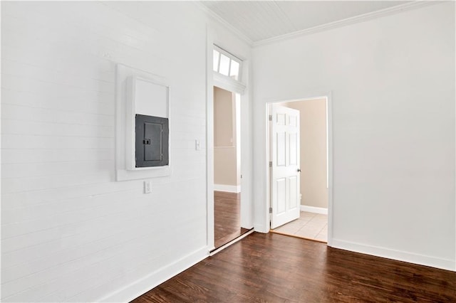 spare room with ornamental molding, electric panel, and wood-type flooring