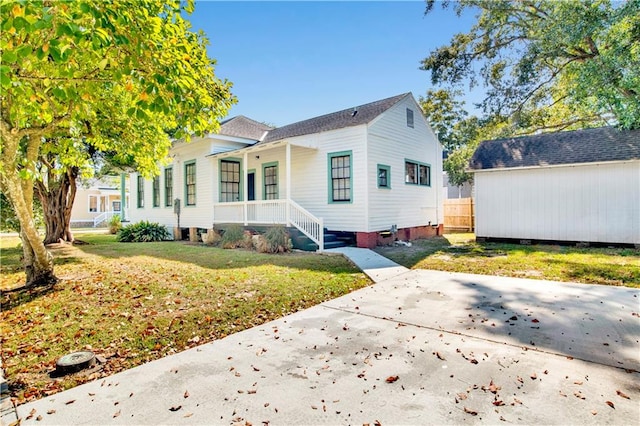 exterior space featuring covered porch and a front lawn