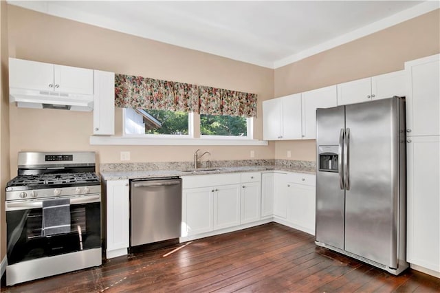 kitchen with dark wood-type flooring, sink, light stone countertops, white cabinets, and appliances with stainless steel finishes